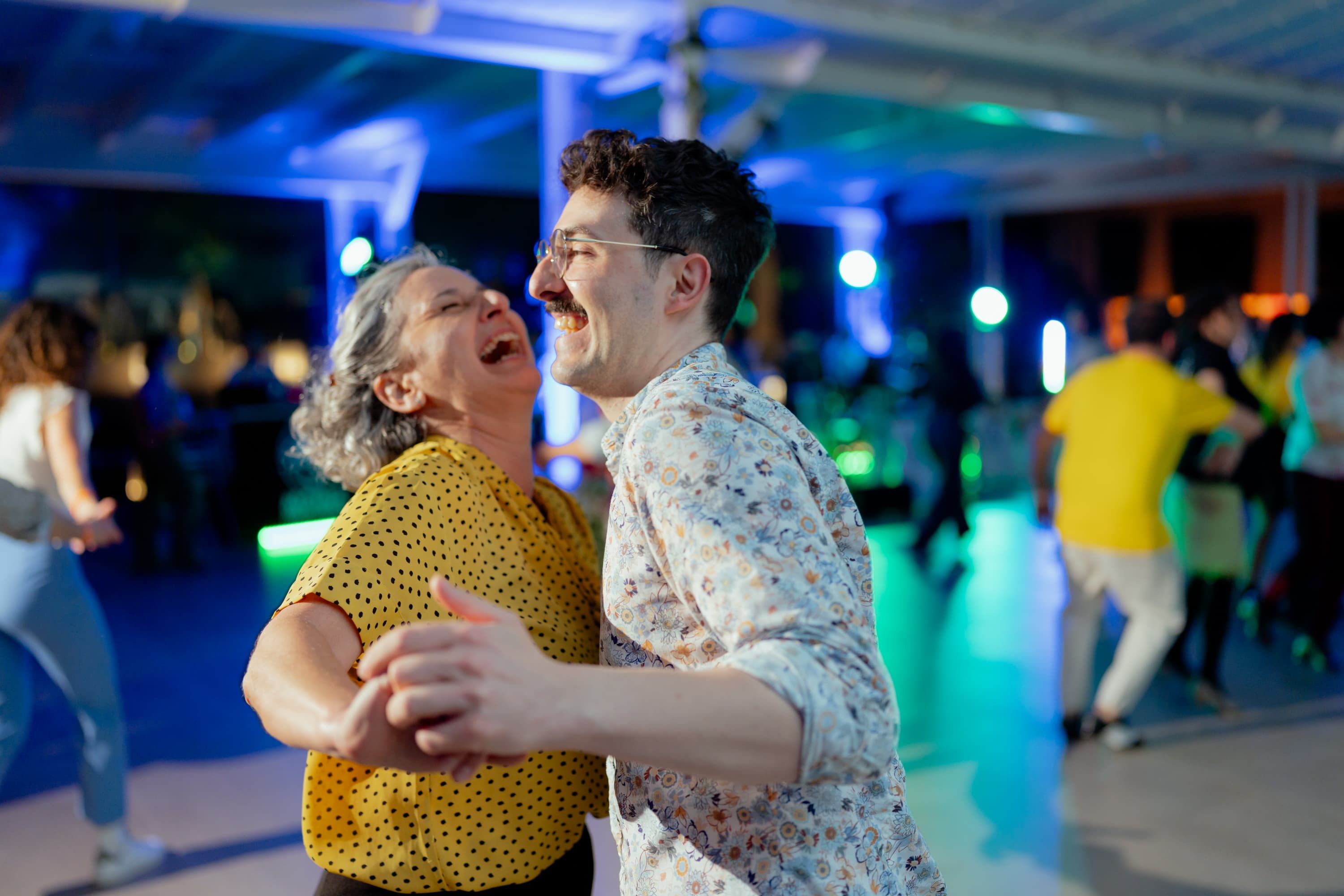 Due allievi ridono di gusto mentre ballano Lindy Hop in coppia